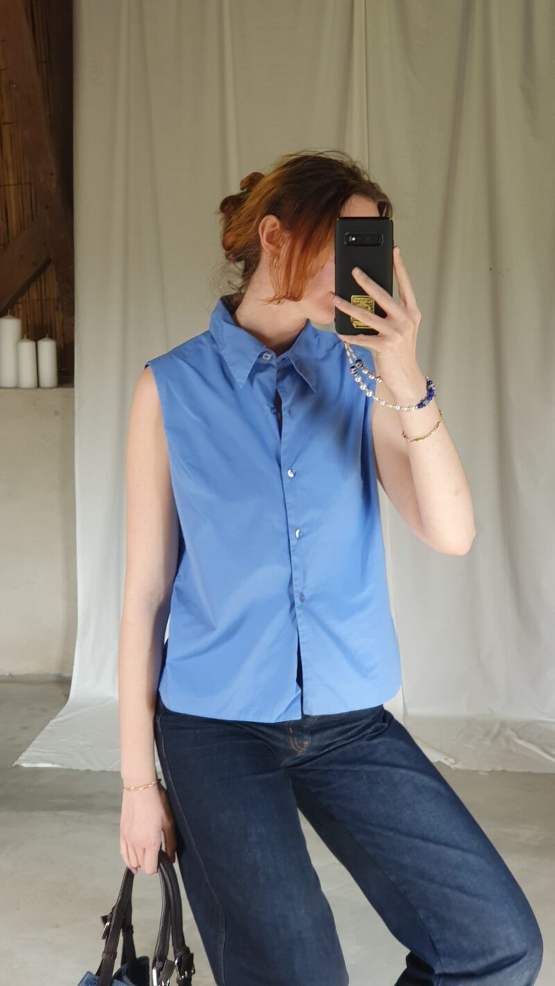 white woman wearing a vintage sleeveless blue shirt