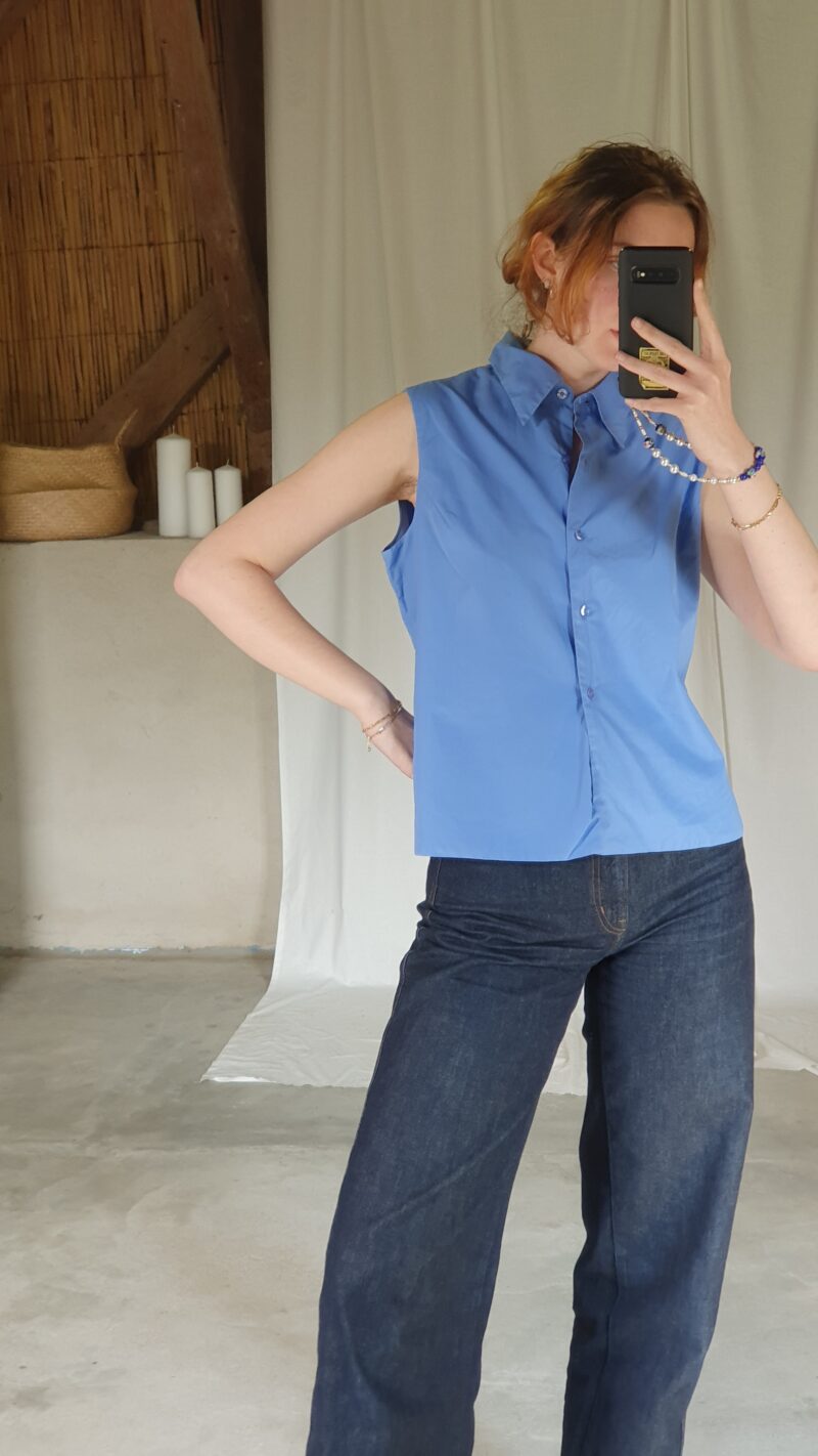 white woman wearing a vintage sleeveless blue shirt