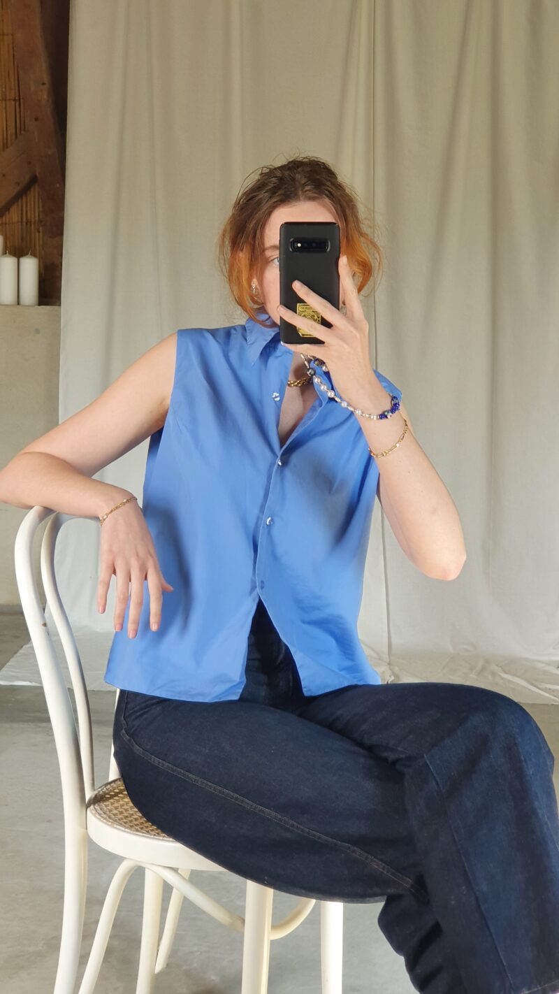 white woman wearing a vintage sleeveless blue shirt