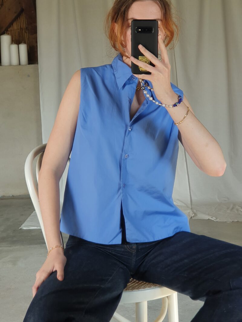 white woman wearing a vintage sleeveless blue shirt