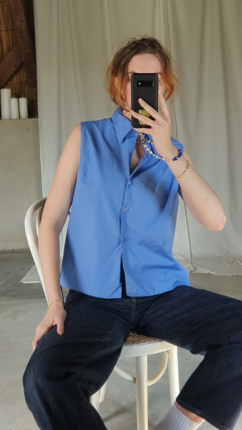 white woman wearing a vintage sleeveless blue shirt